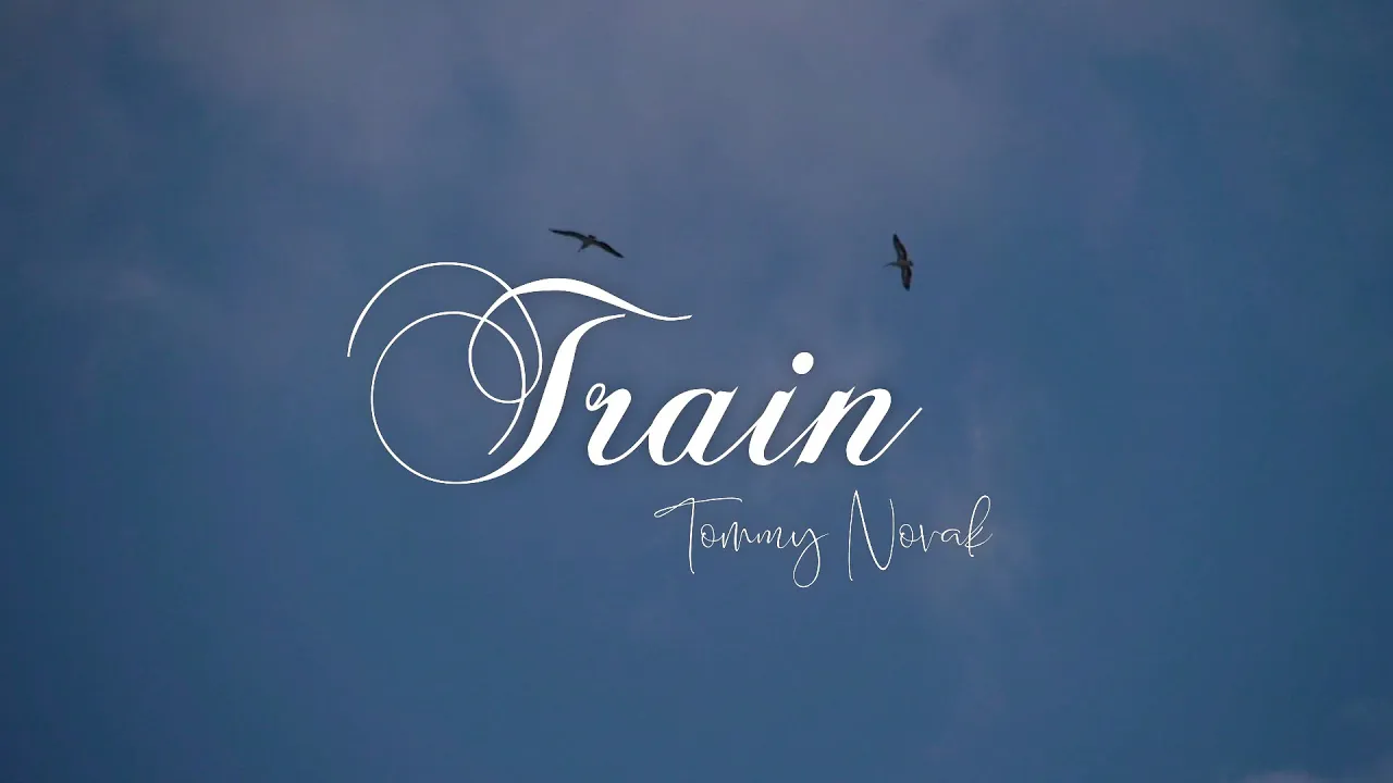Train by Tommy Novak title against a blue sky